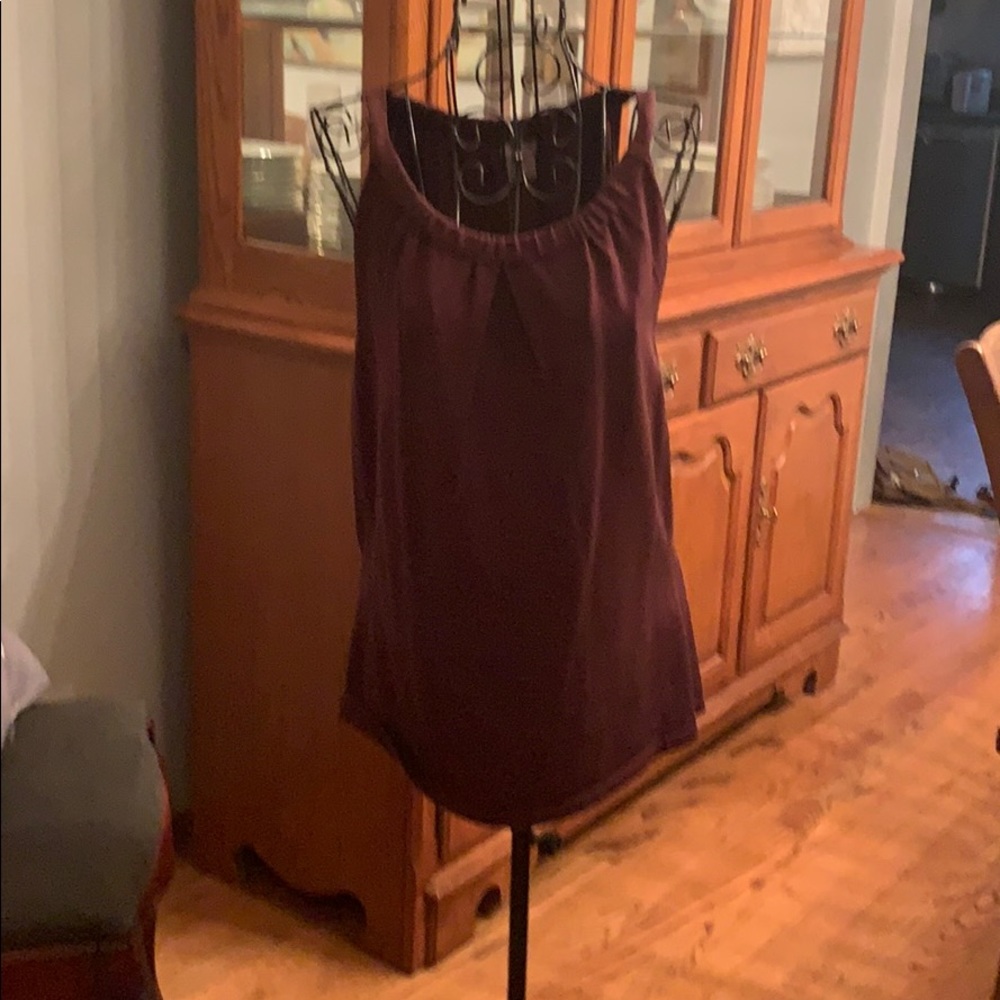 Burgundy sleeveless blouse.